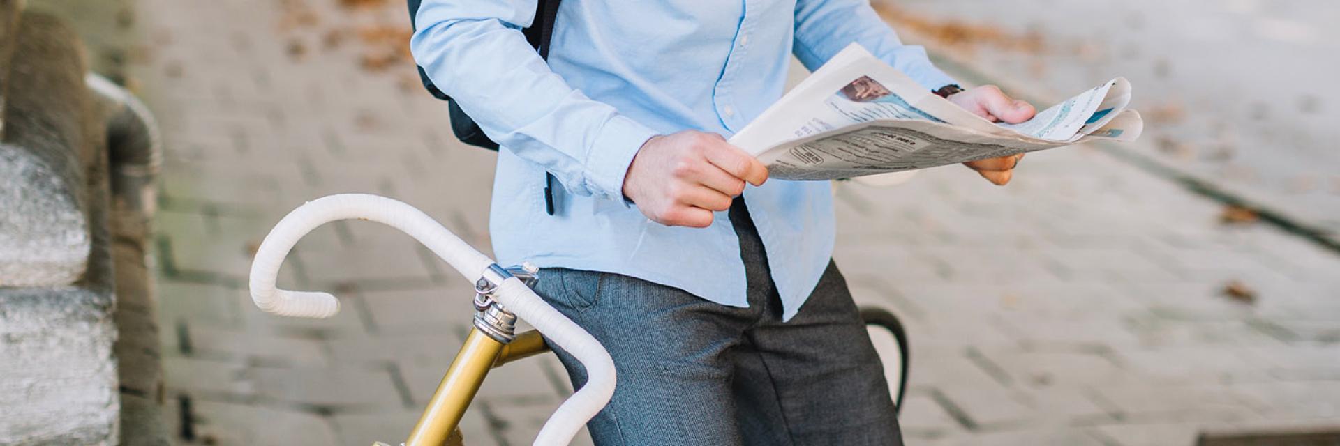 ragazzo che legge notizie in bici